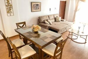 uma sala de estar com uma mesa e cadeiras e um sofá em DEPARTAMENTO MODERNO, ACOGEDOR Y CÉNTRICO. em Sucre