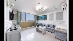 a living room with a couch and a table at Yeosu Beach Hotel in Yeosu