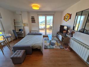 - une chambre avec un lit, une télévision et un balcon dans l'établissement Luminoso apartamento con gran terraza, à Renedo de Piélagos