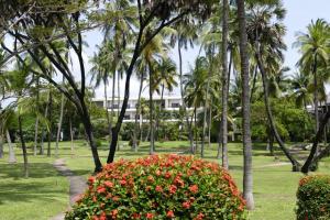 un parque con palmeras y un arbusto con flores en The Lawford powered by ASTON en Malindi