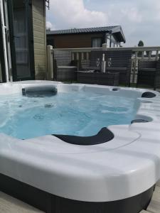 a hot tub on a patio with a house at JJs Lodge Azalea in York