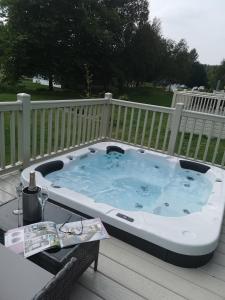 a hot tub on a deck with a table at JJs Lodge Azalea in York