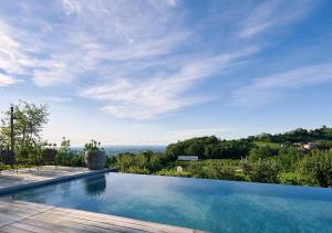 a swimming pool with a view of the countryside at Casale Caldesòra AgriBoutique BnB the Charme in Vittorio Veneto