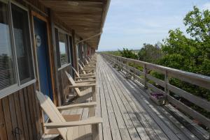a row of chairs sitting on the porch of a building at Ocean Vista Resort in Amagansett
