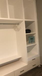 a closet with white cabinets and drawers at Deluxe Apartment in Ensenada in Ensenada