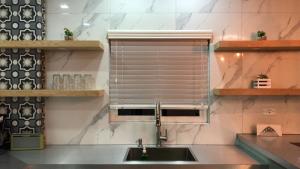 a kitchen with a sink and a window with blinds at Deluxe Apartment in Ensenada in Ensenada +25 photos