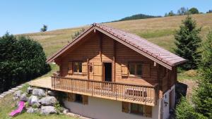 a log cabin on a hill with a balcony at Chalet Les Vosgiennes in Le Valtin