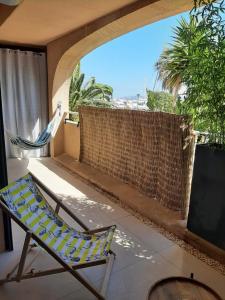 balcón con hamaca y silla en Suites JM - Le temps d'une Escale (Jacuzzi & Vue Mer), en Hyères