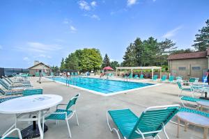 a swimming pool with tables and chairs and a pool at Lakefront Dewittville Condo with Private Deck! in Dewittville