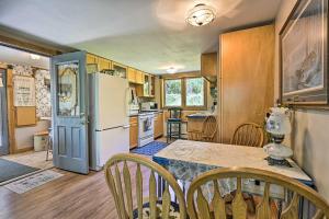 a kitchen with a table and a refrigerator at Lakeside Iola Hideaway: Stunning Nature Views in Iola +21 photos