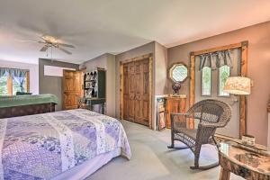 a bedroom with a bed and a chair and a table at Lakeside Iola Hideaway: Stunning Nature Views in Iola