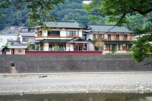 a large house in the middle of a river at IBARA DENIM HOTELS 舞鶴楼 in Ibara
