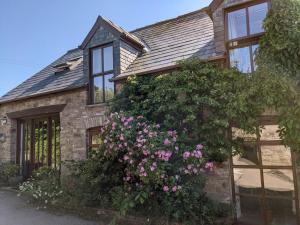 una casa con un gran arbusto de flores en ella en Caecrwn, en Brecon