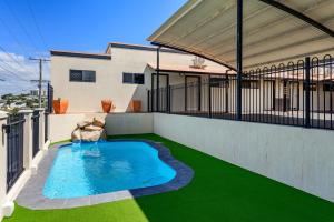 a swimming pool on a balcony with green grass at CQ Motel Gladstone in Gladstone