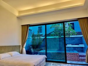 a bedroom with a bed and a large window at Fun Holiday Family Hostel in Tainan +104 photos