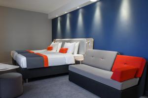 a hotel room with two beds and a chair at Holiday Inn Express - Almaty, an IHG Hotel in Almaty