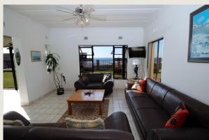 a living room with couches and a table at Eden Dunes 69 in Shelly Beach