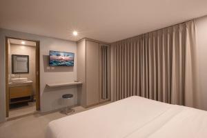 um quarto de hotel com uma cama e uma pia em Lacrissa Bali em Kerobokan mais 14 fotografias