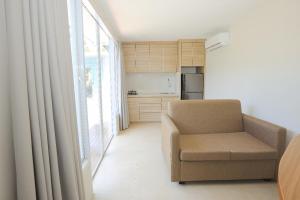 uma sala de estar com uma cadeira e uma cozinha em Lacrissa Bali em Kerobokan