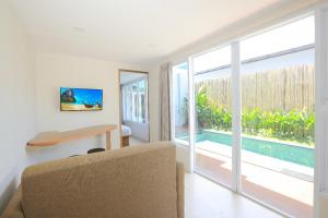 uma sala de estar com uma mesa e uma porta de vidro deslizante em Lacrissa Bali em Kerobokan