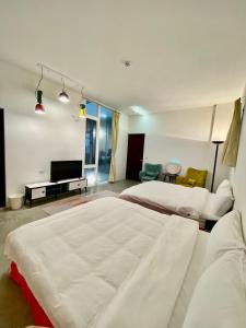 宜蘭市的住宿－宜蘭包棟松悅民宿(原聲原影卡拉OK)，卧室配有一张白色大床和电视。