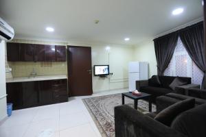 Una sala de estar con un sofá y un televisor. en العييري للشقق المخدومة الدمام 3, en Dammam