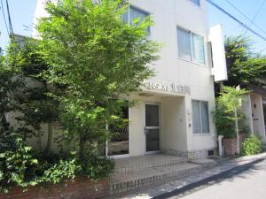 un bâtiment blanc avec un arbre devant lui dans l'établissement Pension Kitashirakawa, à Kyoto