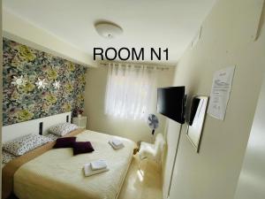 a bedroom with a bed and a room n sign at Marbella Deluxe Rooms in Royal Cabopino Townhouse in Marbella