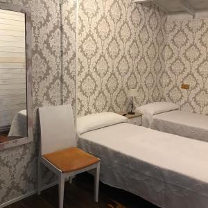 圖瑞蒙戈的住宿－Mirador Los Cotos，一间卧室配有两张床、一把椅子和镜子