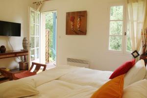 ein Schlafzimmer mit einem Bett, einem Schreibtisch und Fenstern in der Unterkunft Au Petit Bernerot - Les gîtes de l'Arbre Voyageur in Eauze
