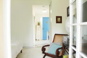 a living room with a blue door and a chair at Au Petit Bernerot - Les gîtes de l'Arbre Voyageur in Eauze