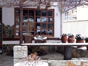 a bench in front of a building with potted plants at Therisso Rooms in Thérison