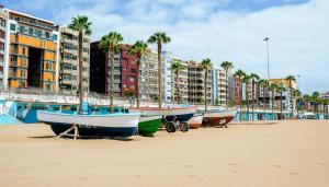 dos barcos en la playa frente a los edificios en GR CANTERAS BEACH, en Las Palmas de Gran Canaria
