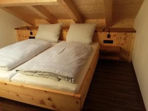 a bedroom in a log cabin with a bed at Ferienwohnungen Satzger in Mittenwald