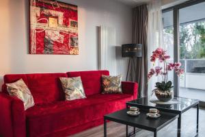 a red couch in a living room with a table at D Apartments Centrum Jurowiecka III in Białystok
