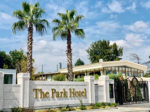 a park hotel with palm trees behind a gate at Istanbul Park Hotel in Tuzla