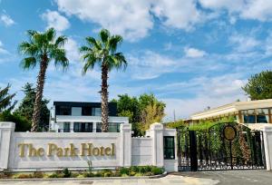 a park hotel with palm trees behind a gate at Istanbul Park Hotel in Tuzla