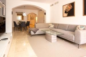 a living room with a couch and a table at Ground Floor Apartment, Los Jardines de Santa Maria Elviria in Marbella