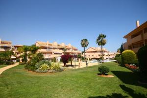 a park in a resort with palm trees and houses at Ground Floor Apartment, Los Jardines de Santa Maria Elviria in Marbella