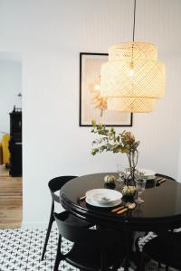 a black dining room table with a chandelier at Poetry Apartments in the city center in Kharkiv