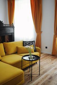 a living room with a yellow couch and a table at Poetry Apartments in the city center in Kharkiv