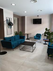 ein Wohnzimmer mit einem blauen Sofa und Stühlen in der Unterkunft Hotel Emiliana in Villadossola