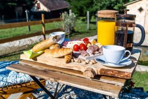 einen Tisch mit einem Teller Essen und einem Krug Saft in der Unterkunft AgroPing Korosajt Műhely in Nemesbükk
