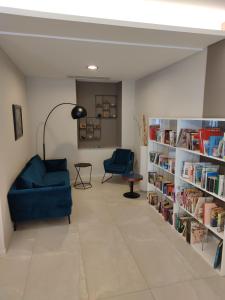 a living room with a blue couch and bookshelves at Hotel Emiliana in Villadossola