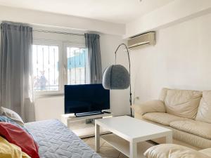 uma sala de estar com um sofá e uma televisão em Sanny's Place em Kavala
