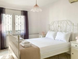 um quarto branco com uma cama branca e uma janela em Sanny's Place em Kavala