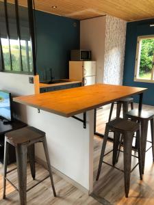 a kitchen with a large wooden table and stools at Le Montagnon in Lupé