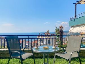 una mesa y 2 sillas en un balcón con vistas al océano en Sanny's Place, en Kavala