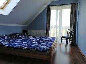 sypialnia z łóżkiem, krzesłem i oknem w obiekcie Apartament Mysłakowice w mieście Mysłakowice