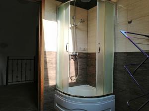 La salle de bains est pourvue d'une douche avec une porte en verre. dans l'établissement Apartament Mysłakowice, à Mysłakowice